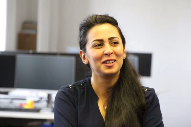 A colleague in conversation at her desk